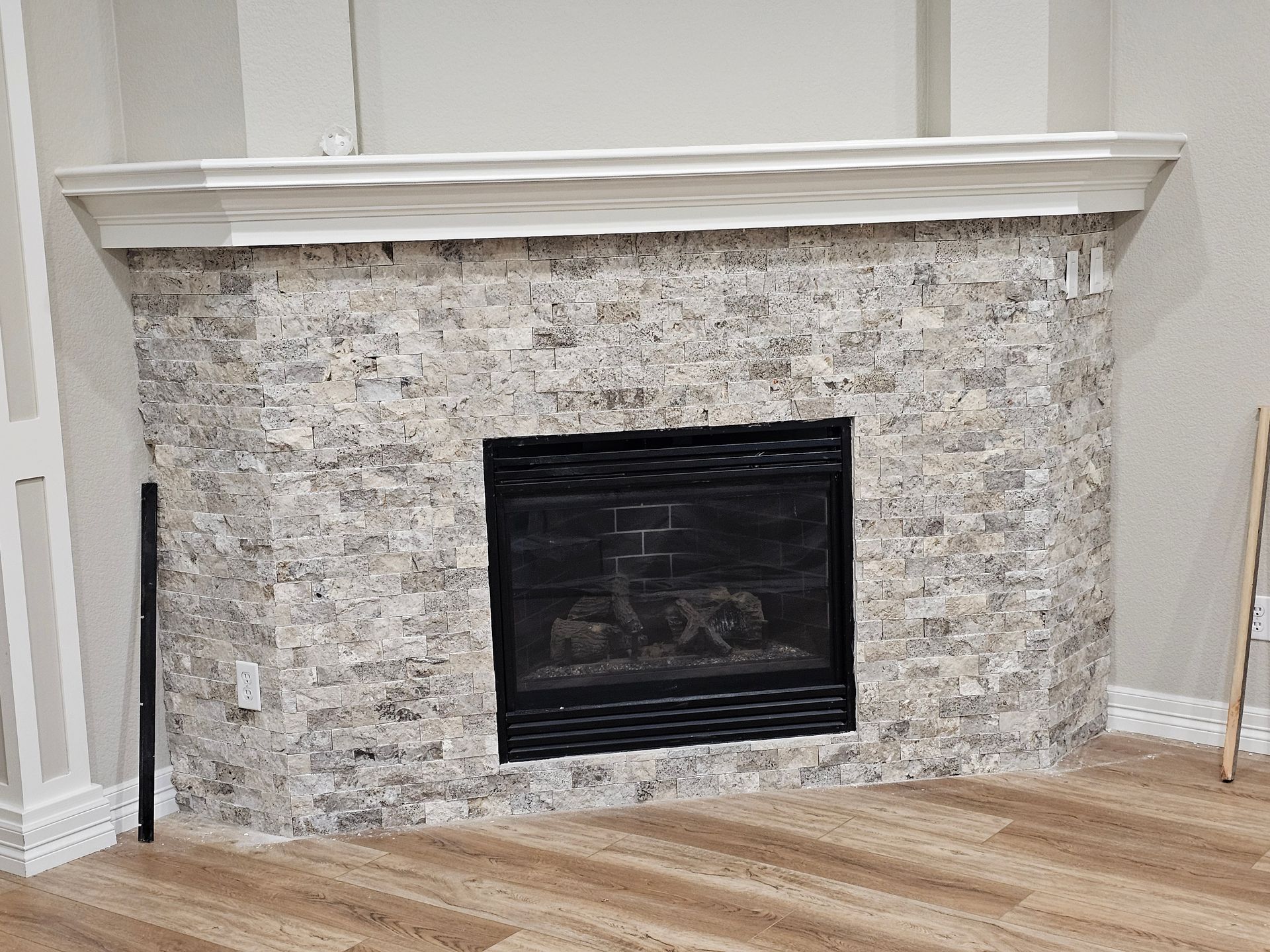 A living room with a fireplace and a wooden floor.