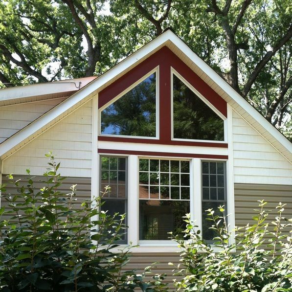 A white house with a red triangle shaped window