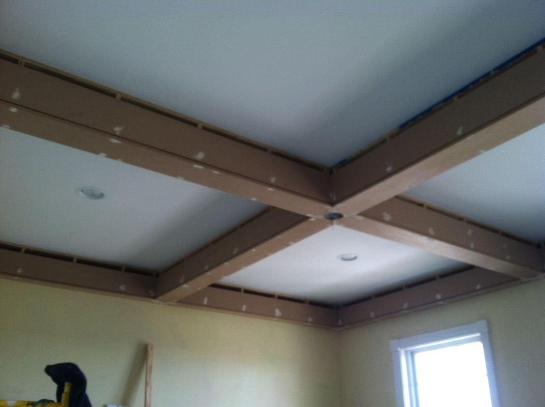 A room with a white ceiling and wooden beams