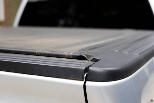 A close up of a truck bed with a black cover on it.
