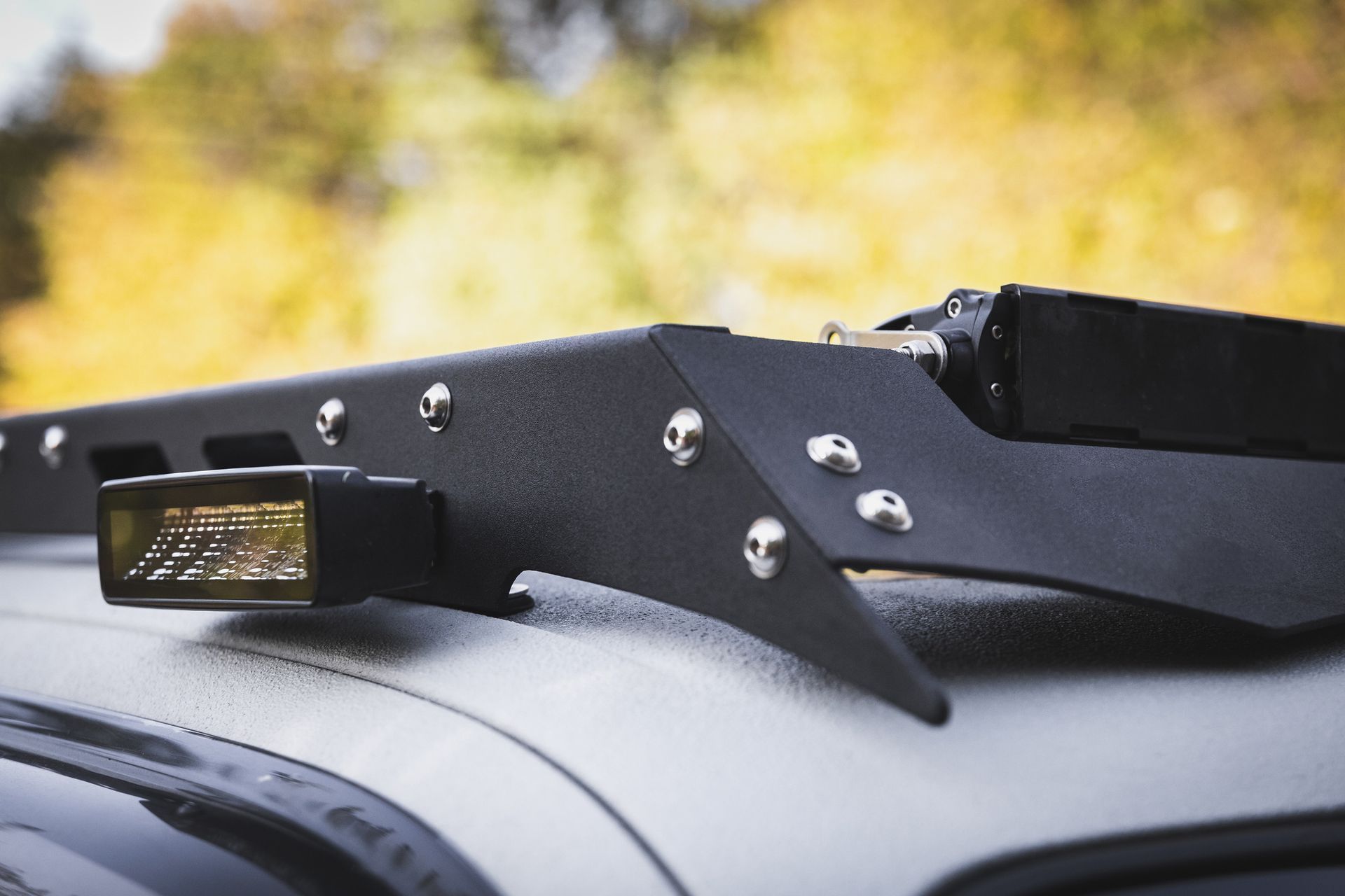 A roof rack with a light attached to it on top of a car.