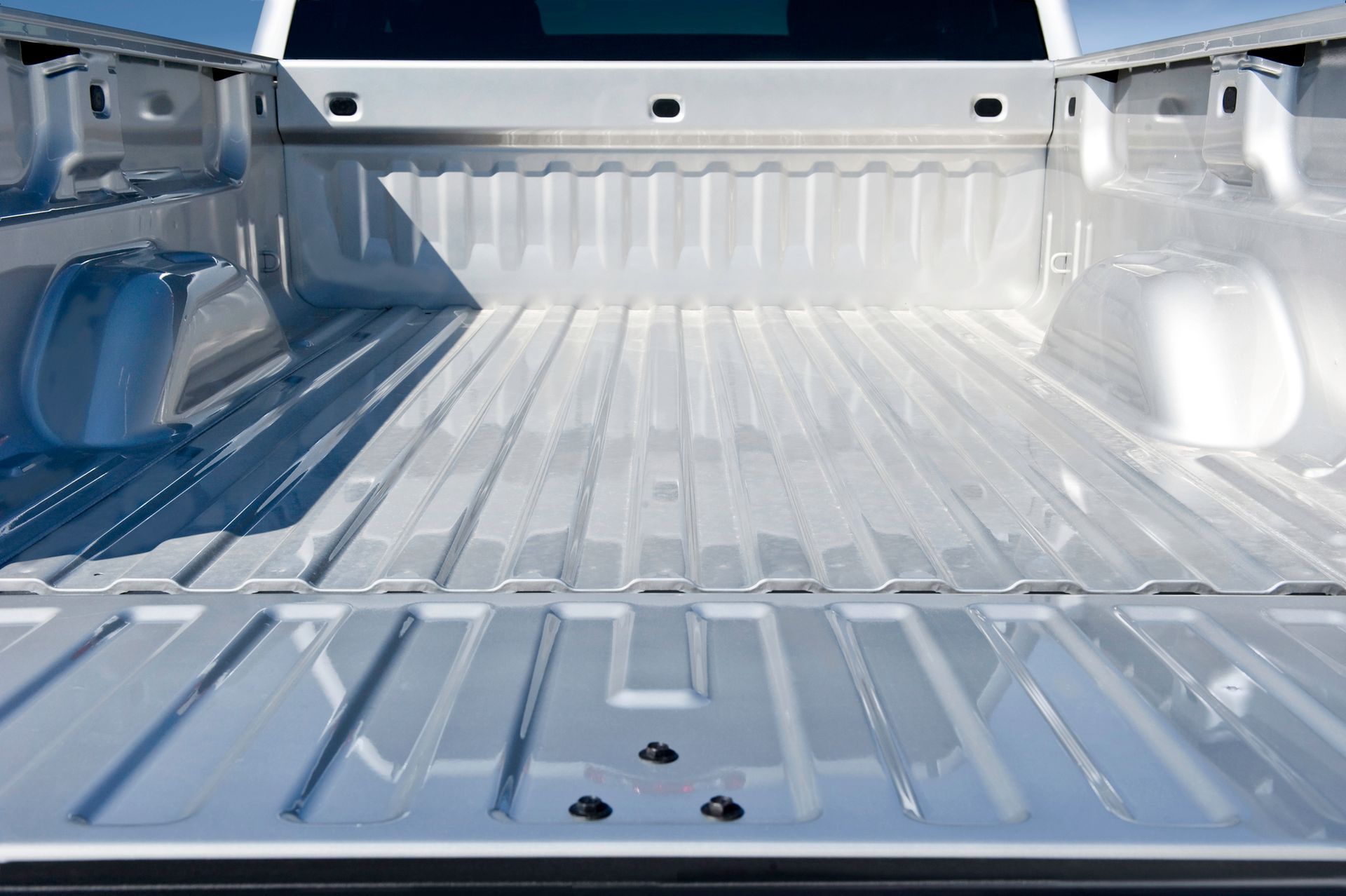 The back of an empty white truck with a blue sky in the background