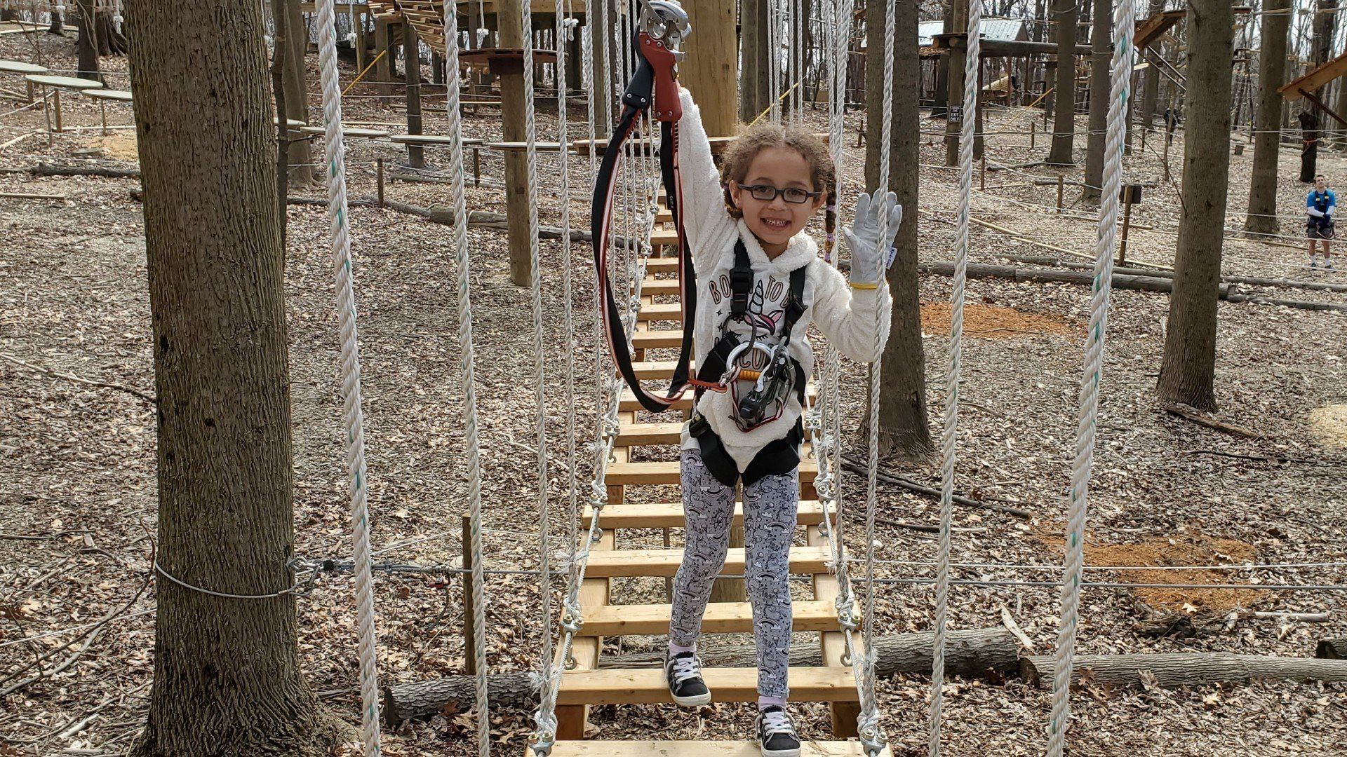 Young girl climbing on challenge course obstacle