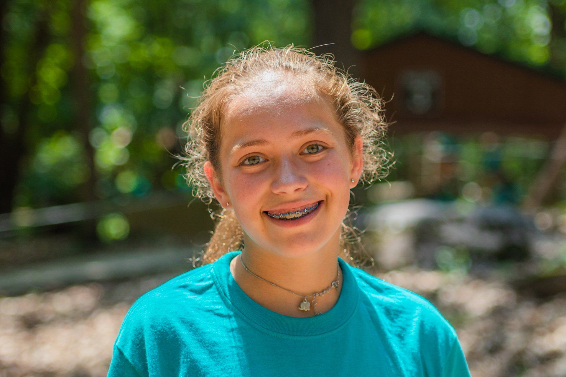 Adolescent girl smiling in the sun at summer camp