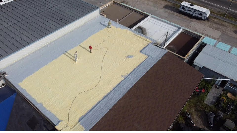 A snowy roof with a building in the background