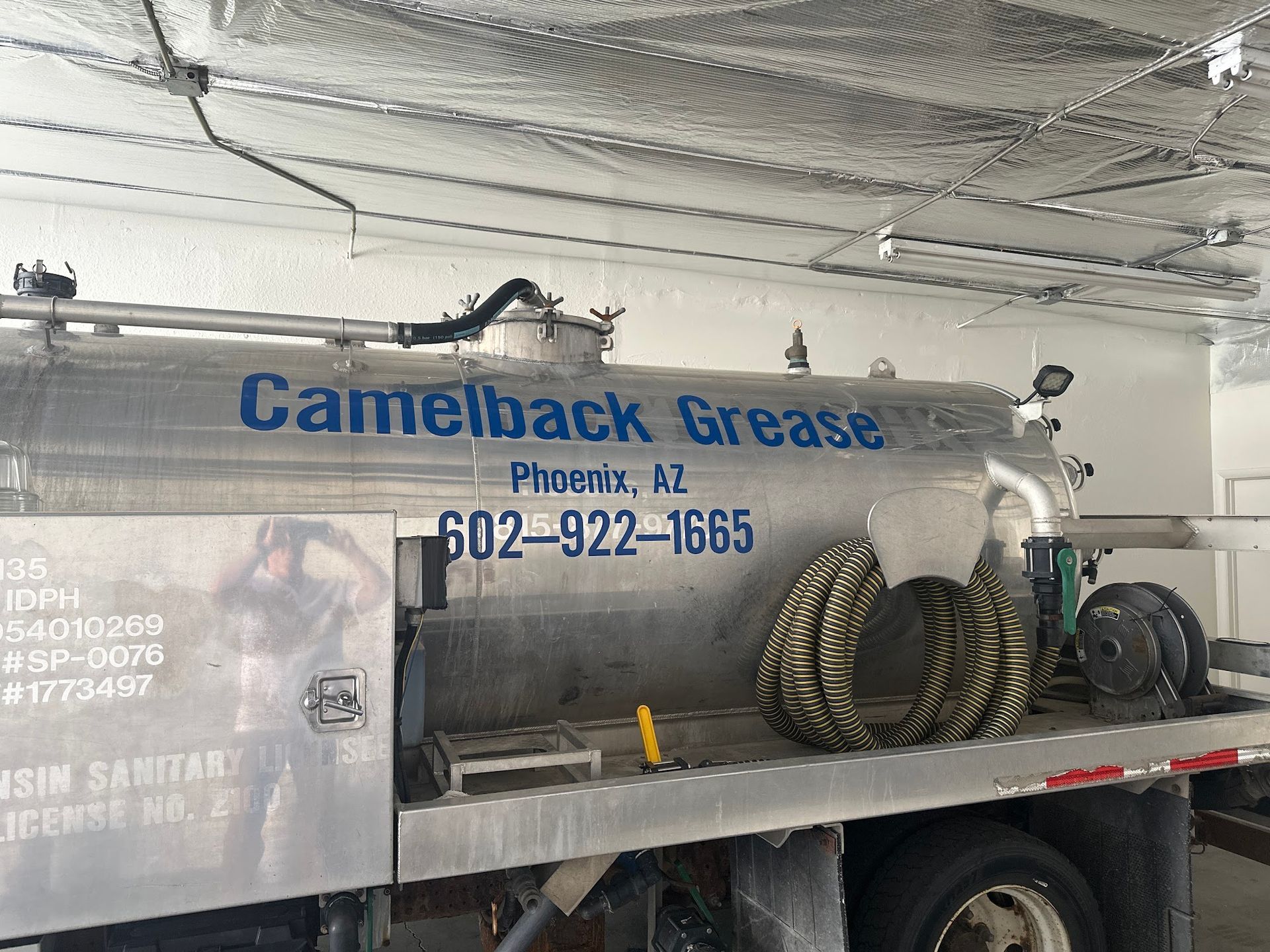 Camelback Grease truck in Phoenix, AZ, with phone number, parked inside a building.