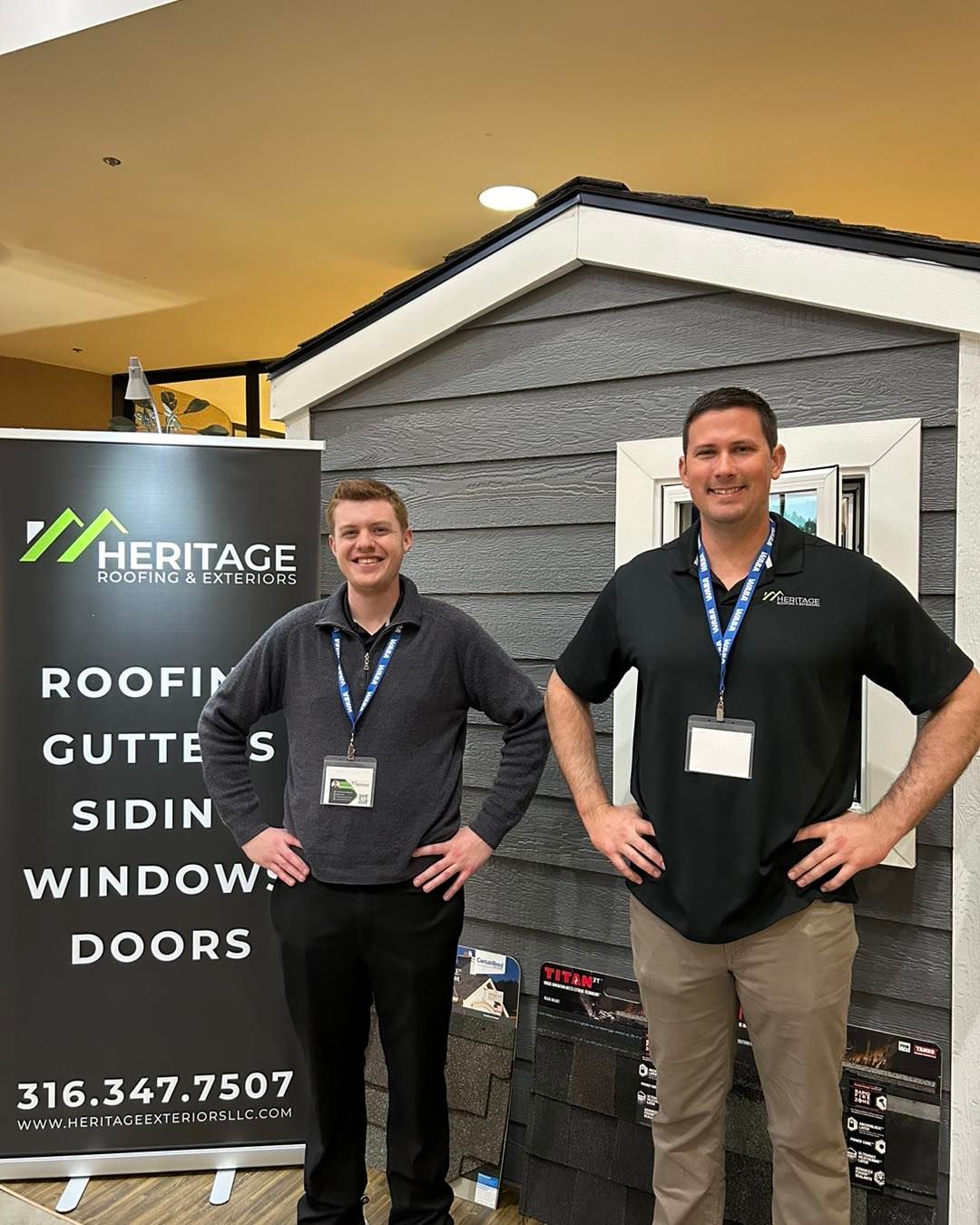 Two men are standing next to each other in front of a sign.