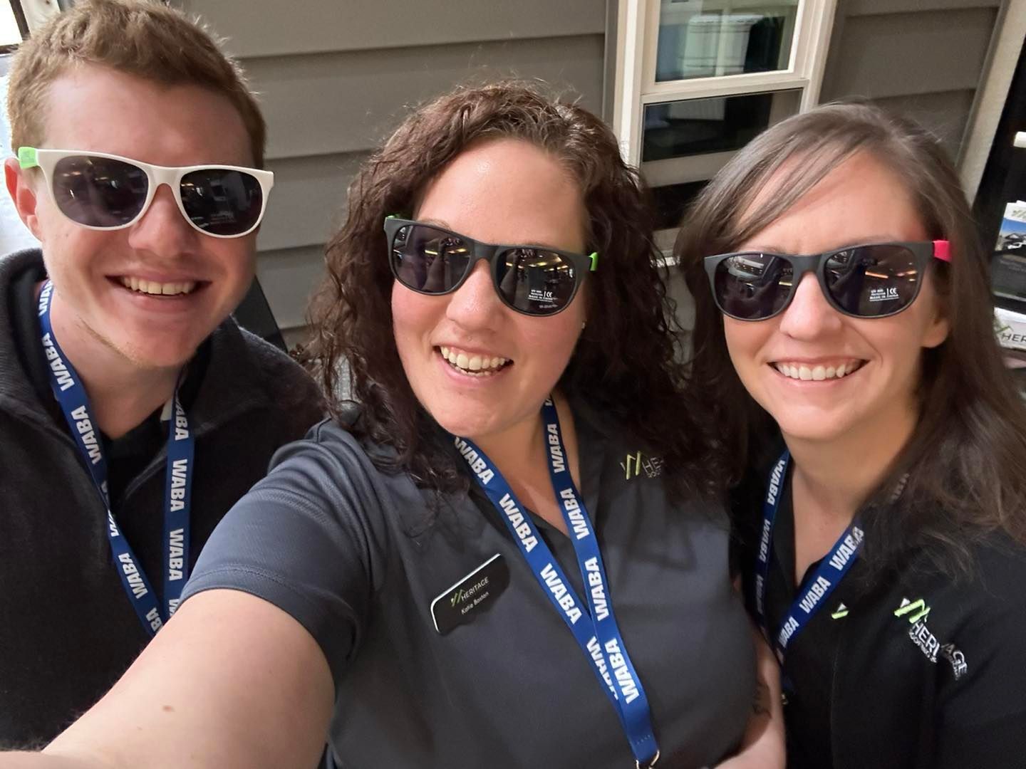 A man and two women wearing sunglasses are posing for a picture
