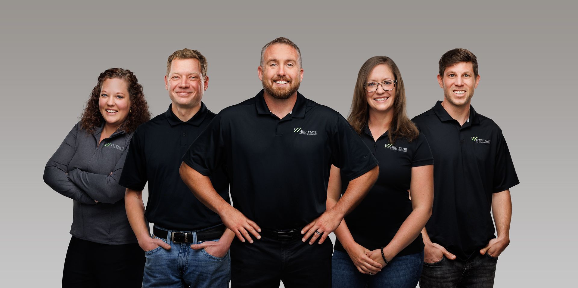 A group of people in black shirts are posing for a picture.
