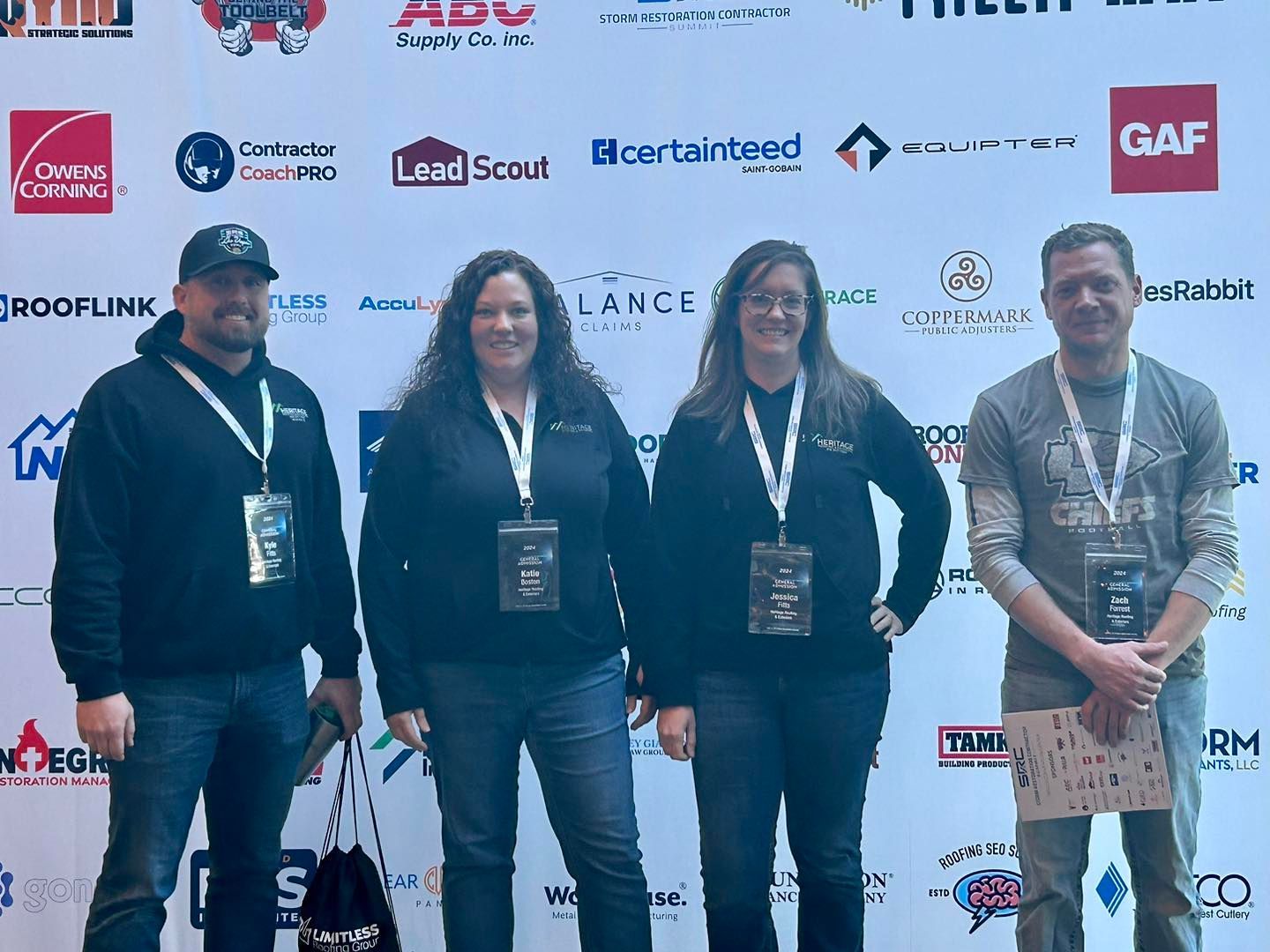 A group of people standing in front of a wall with logos on it