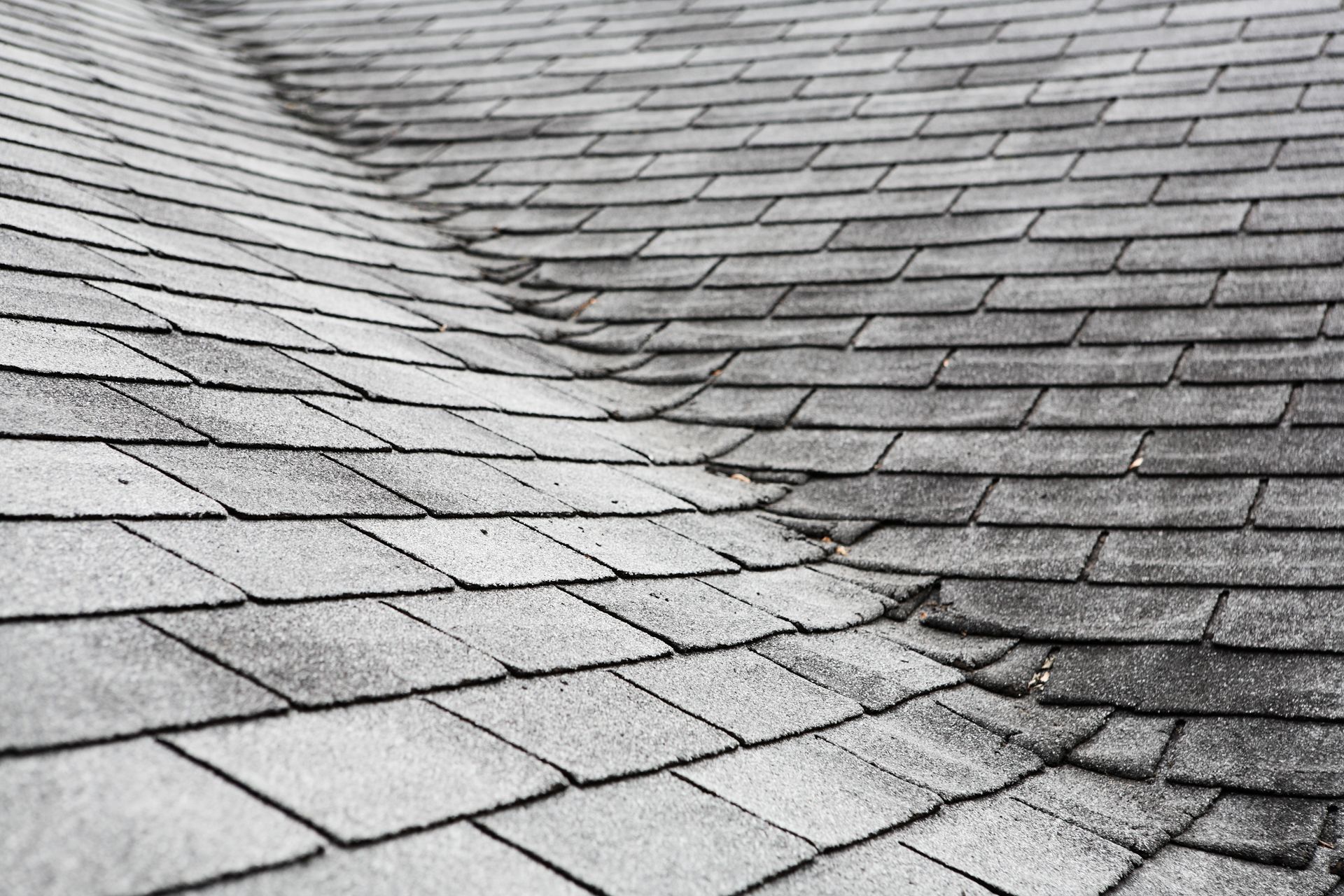 A black and white photo of a roof with shingles on it.