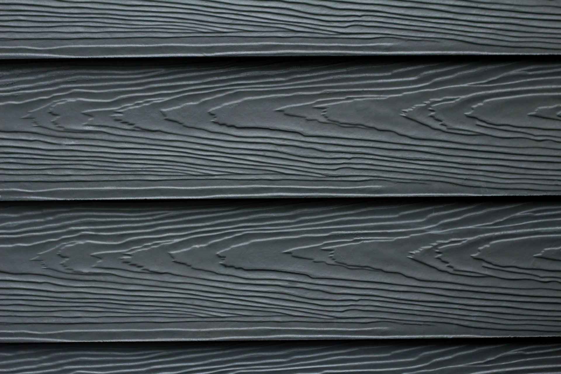 A close up of a black wooden siding on a house.