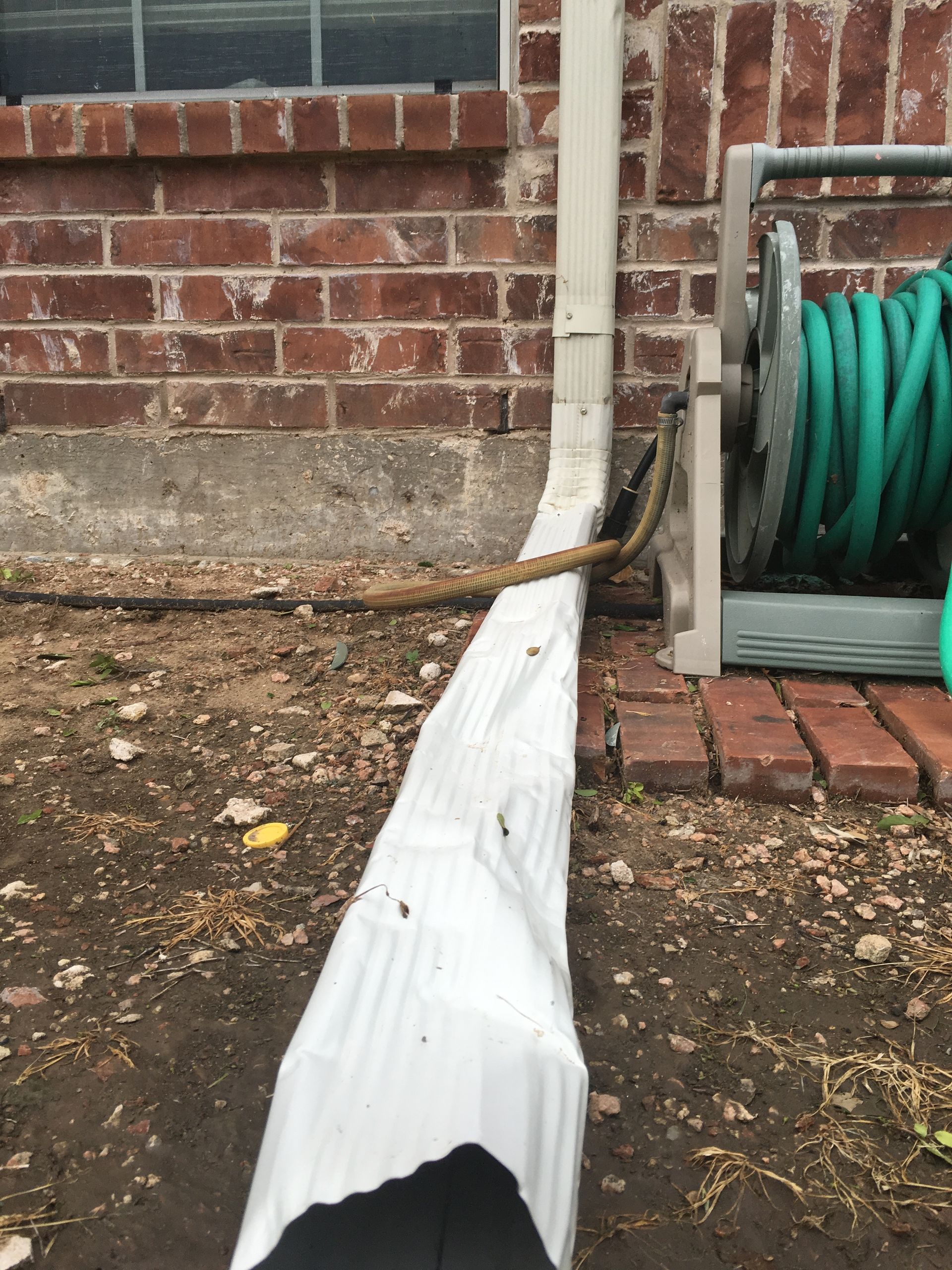 A hose reel with a green hose attached to it