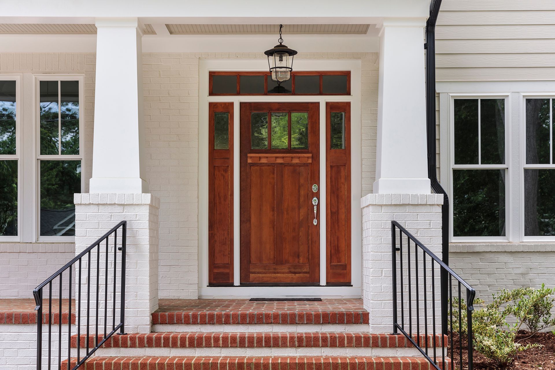 The front door of a house with a wooden door and brick steps.