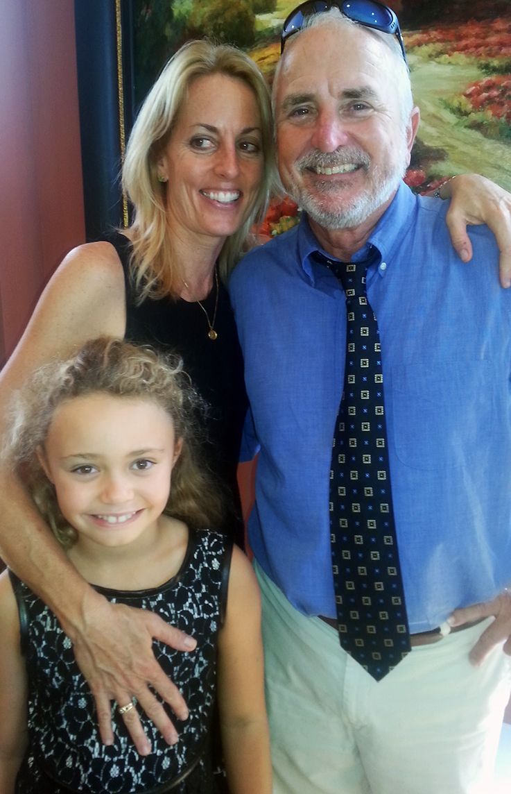 Family of three smiling at the camera.