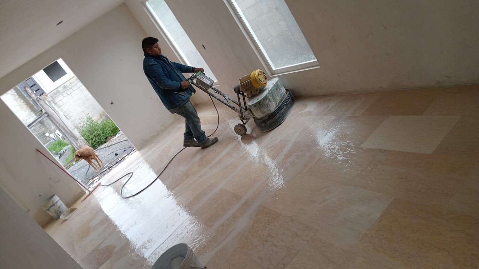 Un hombre está puliendo un piso de mármol con una máquina.