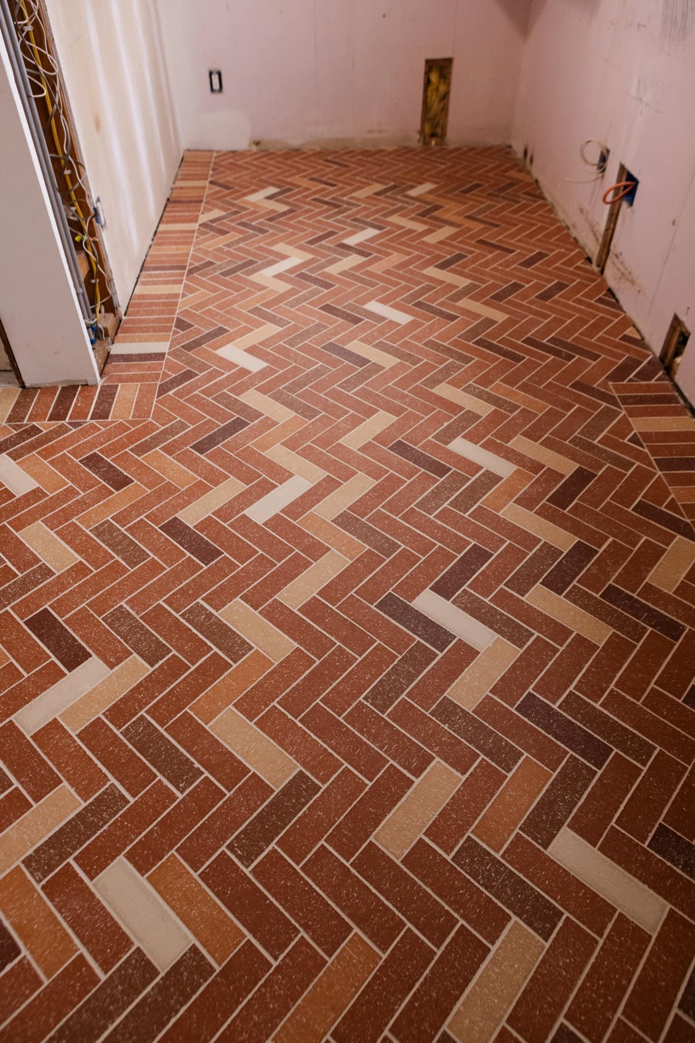 A brick floor with a herringbone pattern in a room.