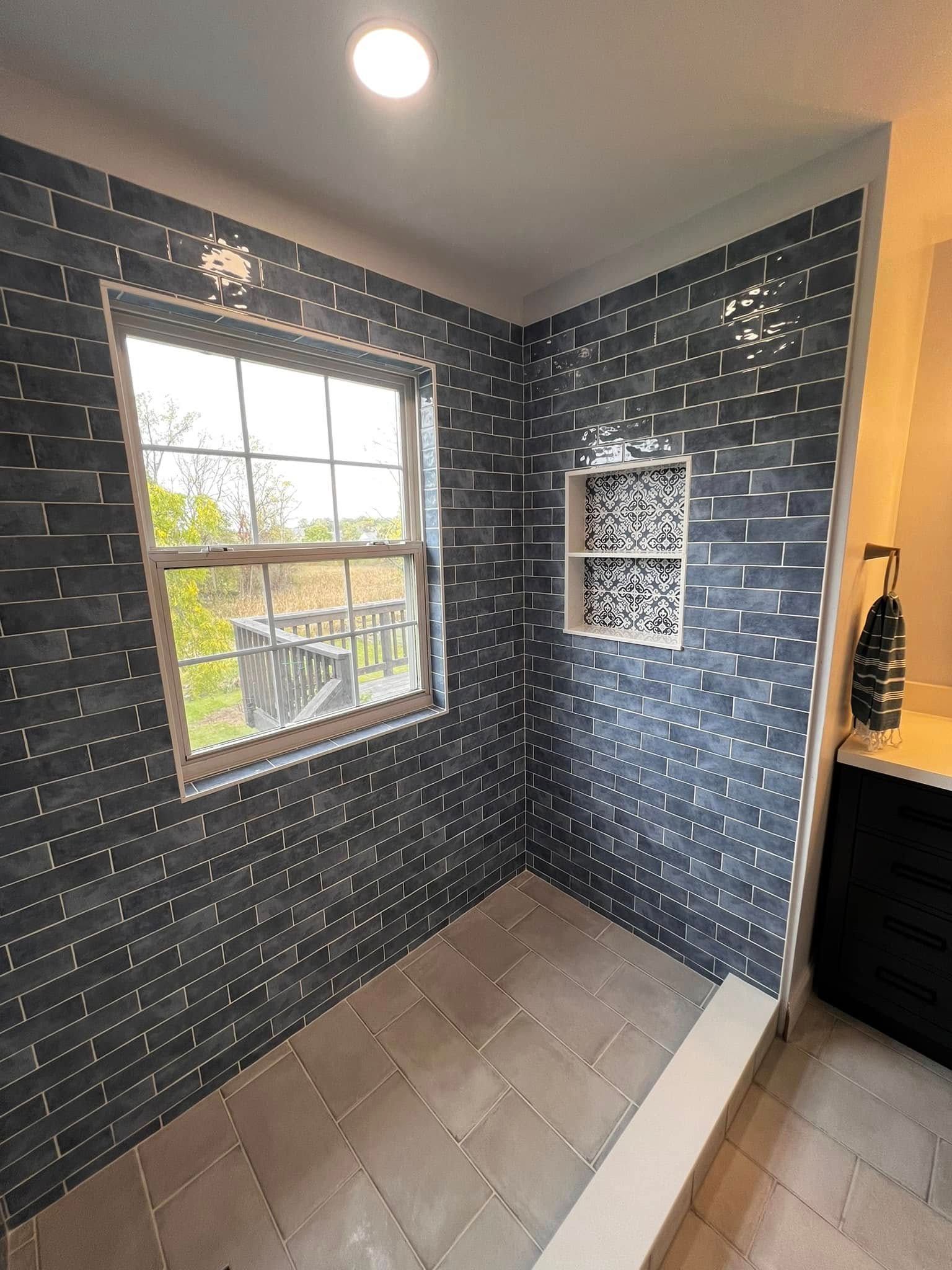 A bathroom with a walk in shower and a window.