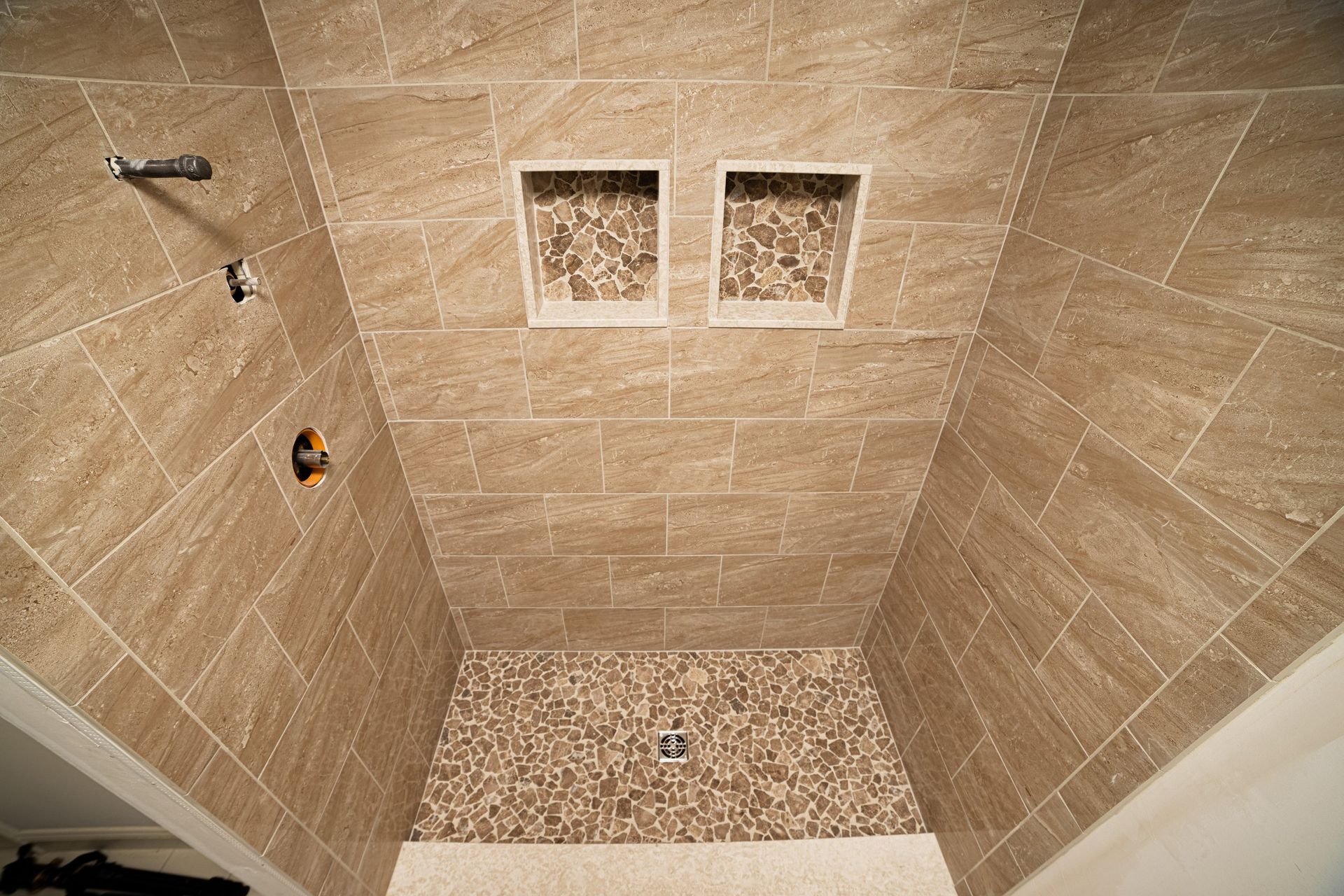 A bathroom with a walk in shower with two niches on the wall.