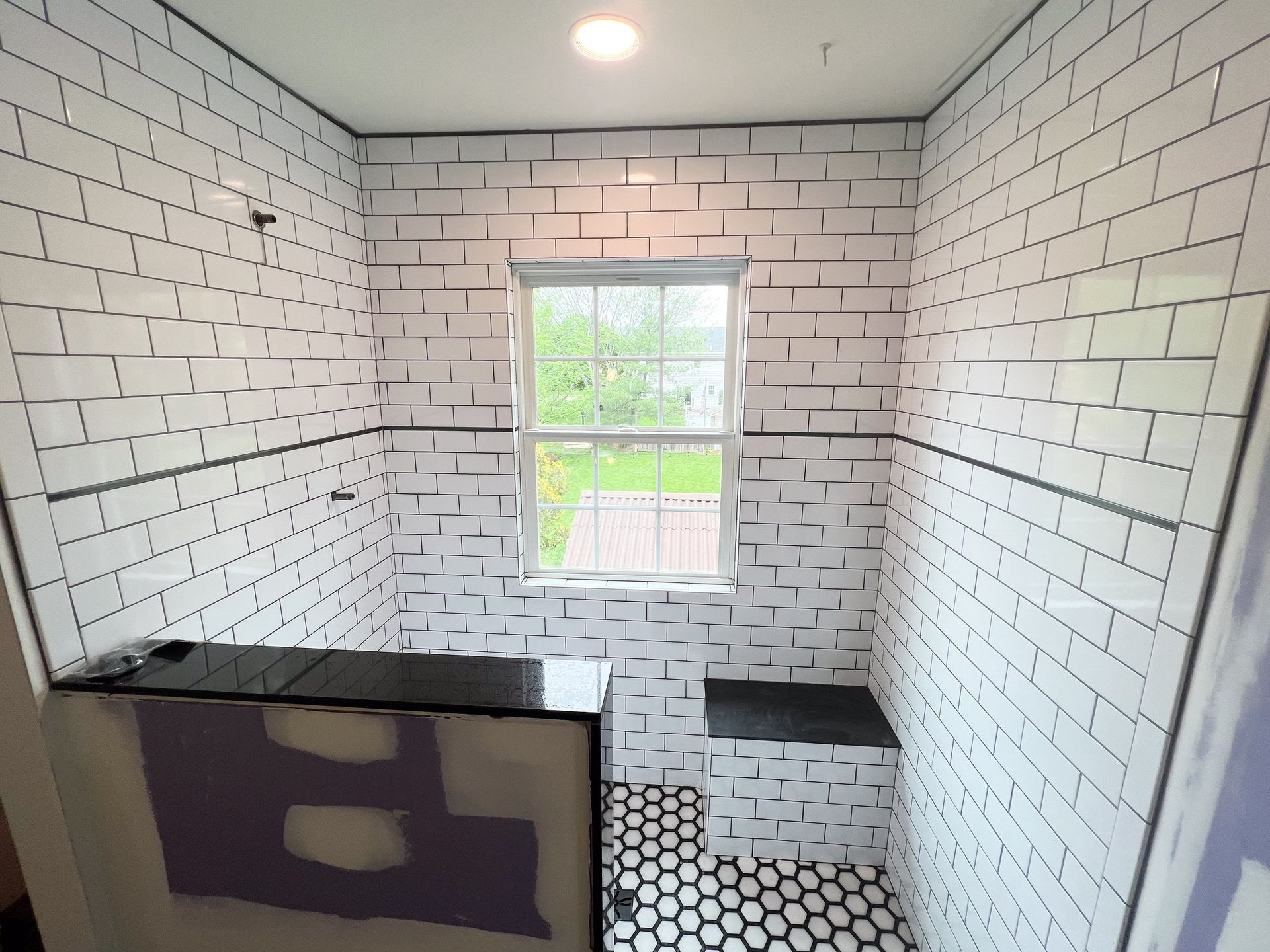 A bathroom with white brick walls and a window