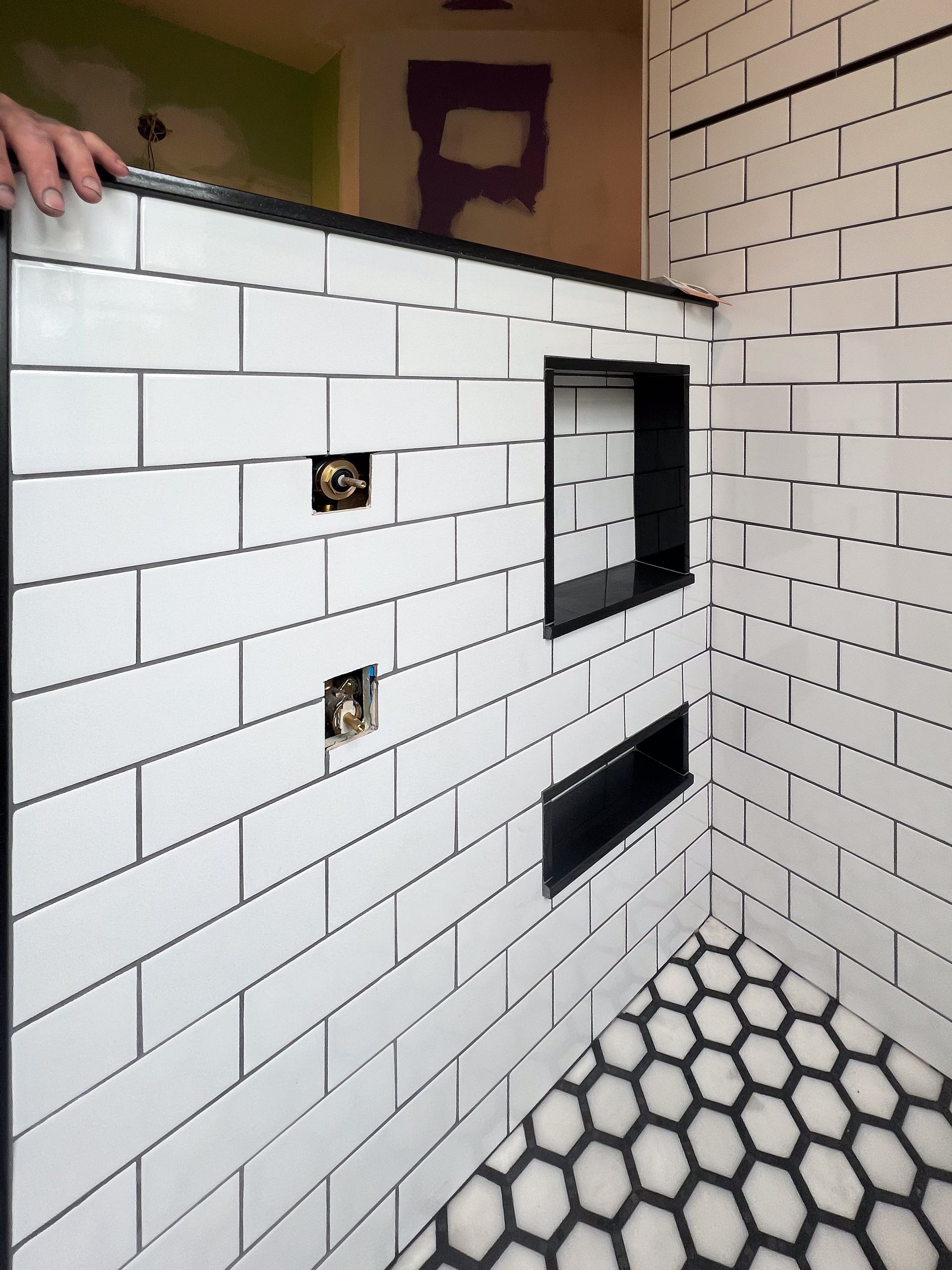 A white brick wall with a purple letter b on the wall