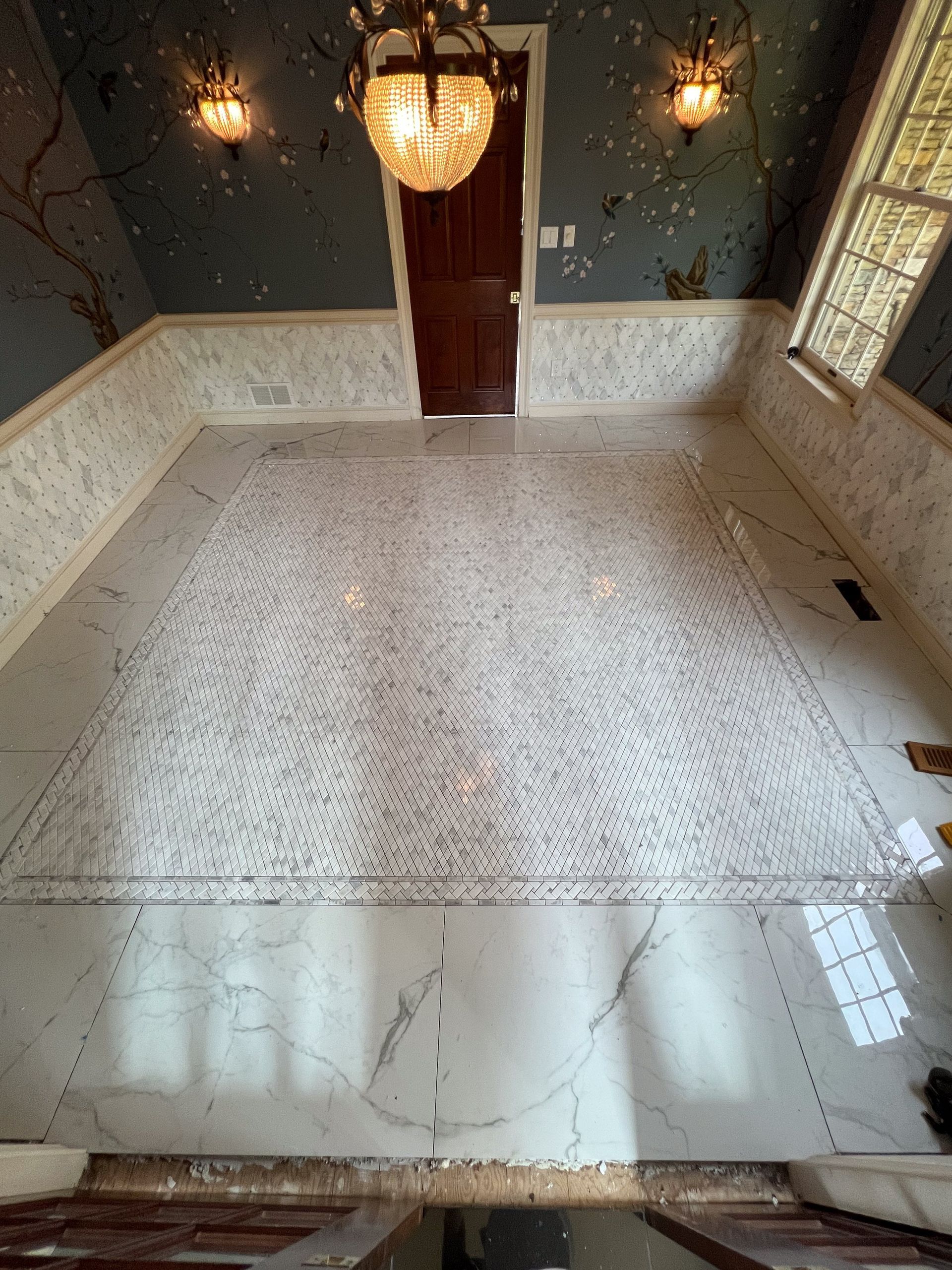A room with a marble floor and a chandelier hanging from the ceiling.
