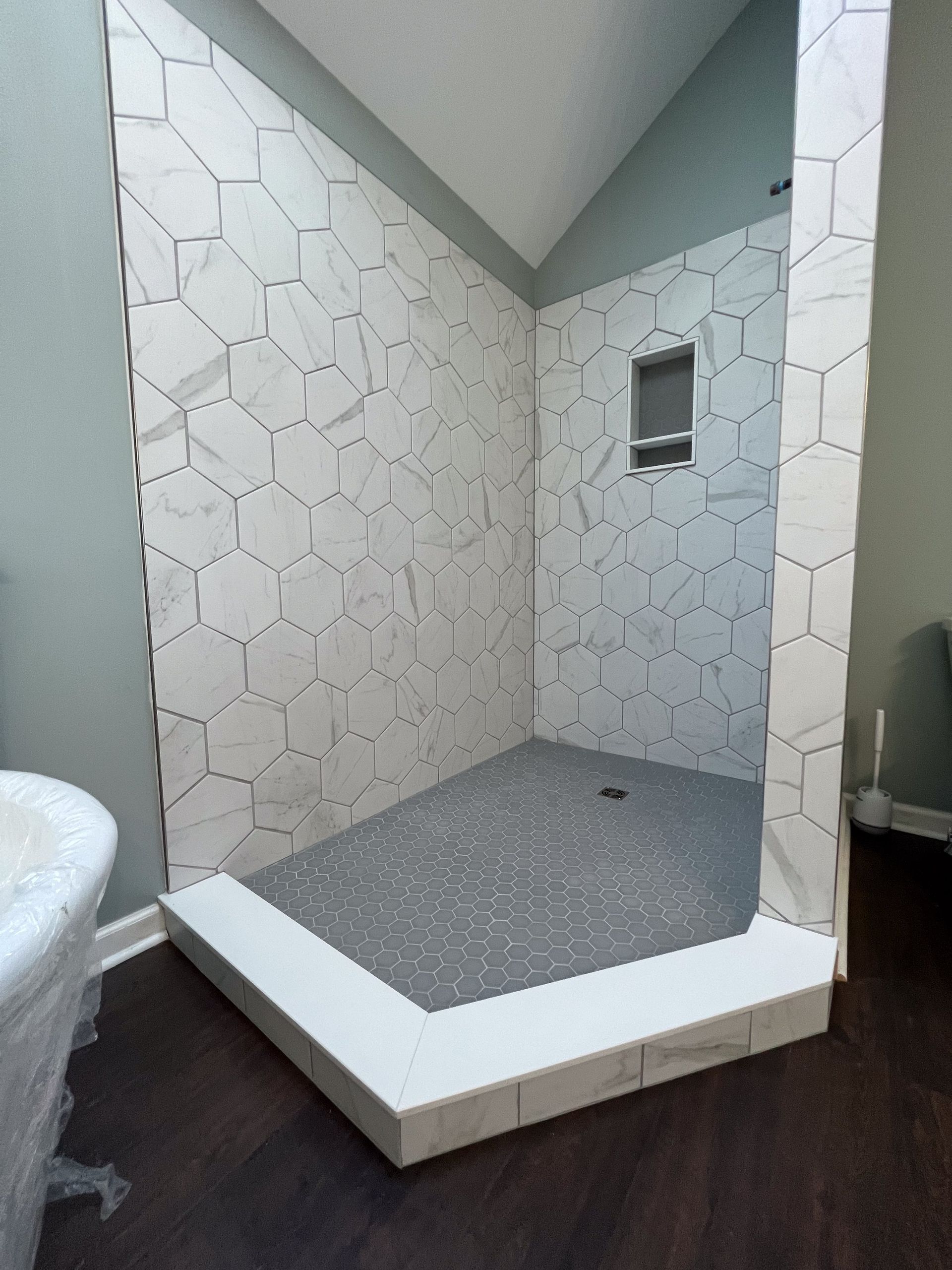 A bathroom with a walk in shower and a sink.