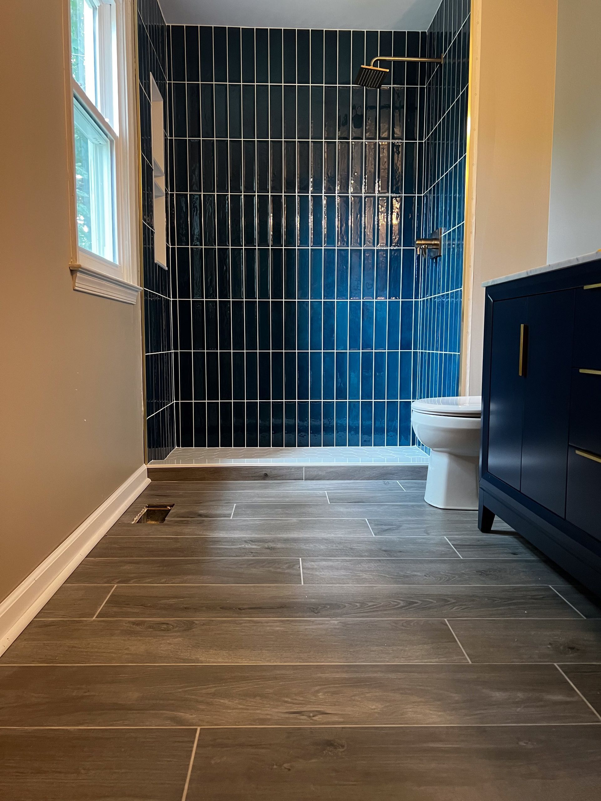 A bathroom with a toilet , sink and shower.