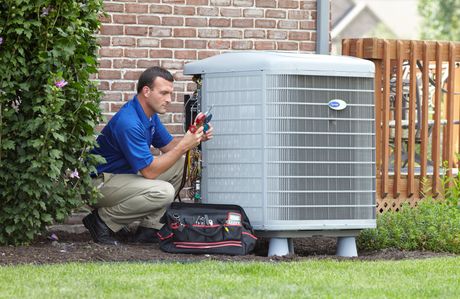 An air conditioning technician inspects an air conditioner.