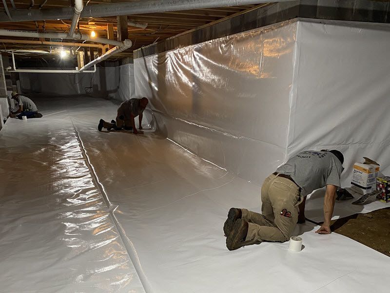 Speir technicians install a vapor barrier in a crawl space.