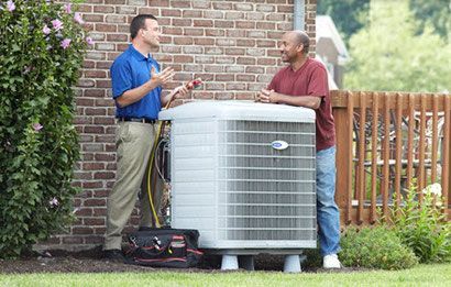 Air conditioner technician discusses a new unit to a male homeowner.