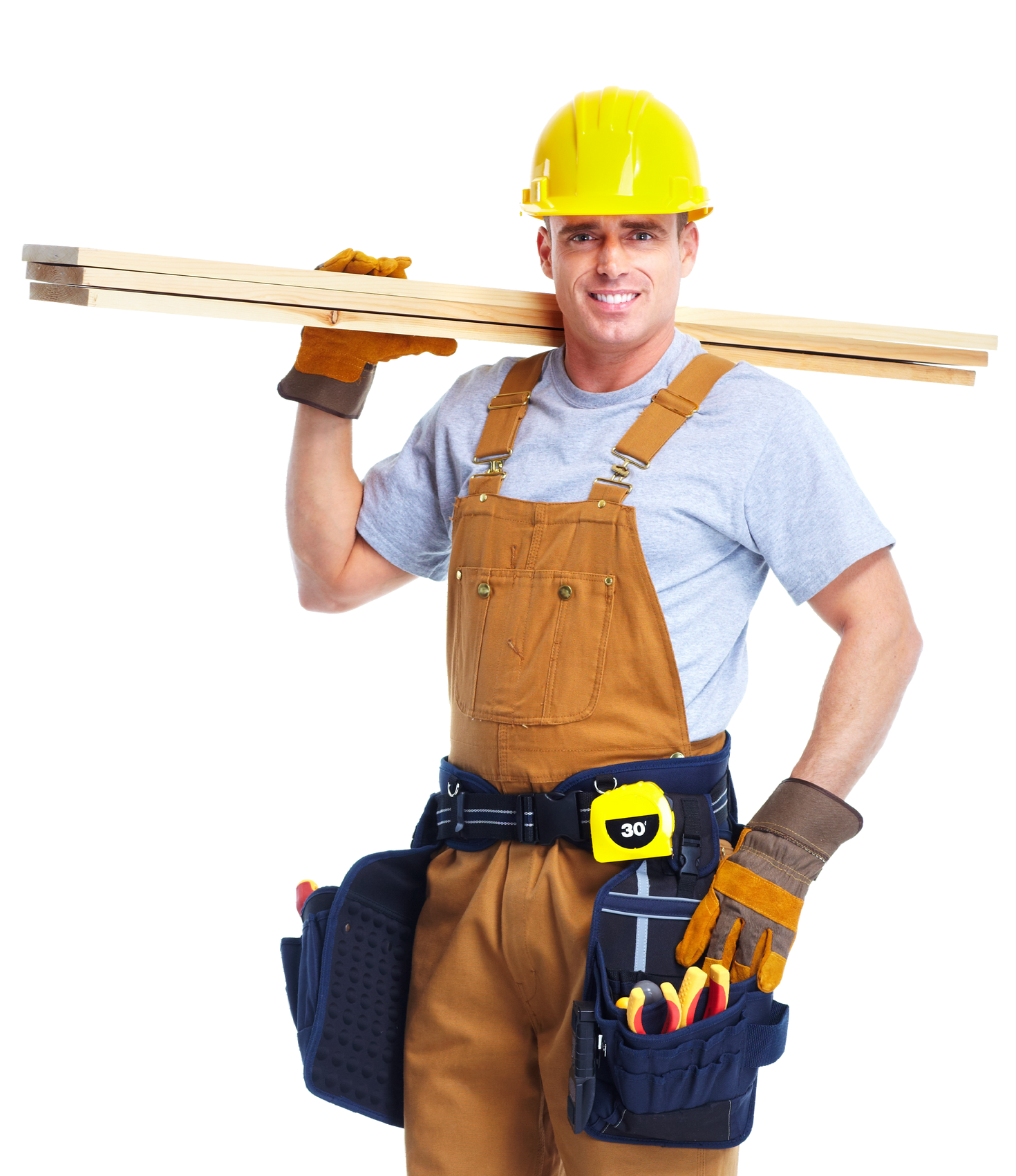 A man wearing overalls and a hard hat is carrying a piece of wood on his shoulder