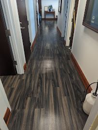 A hallway with hardwood floors and a mirror on the wall.