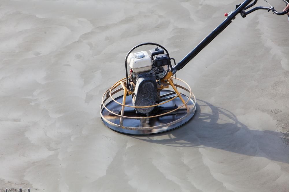 A Person Is Using a Trowel on A Concrete Surface — TNT Floor Removal & Demolition in Tewantin, QLD