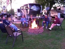 A group of people are sitting around a fire pit.