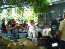 A group of people are standing around a table in front of a building.