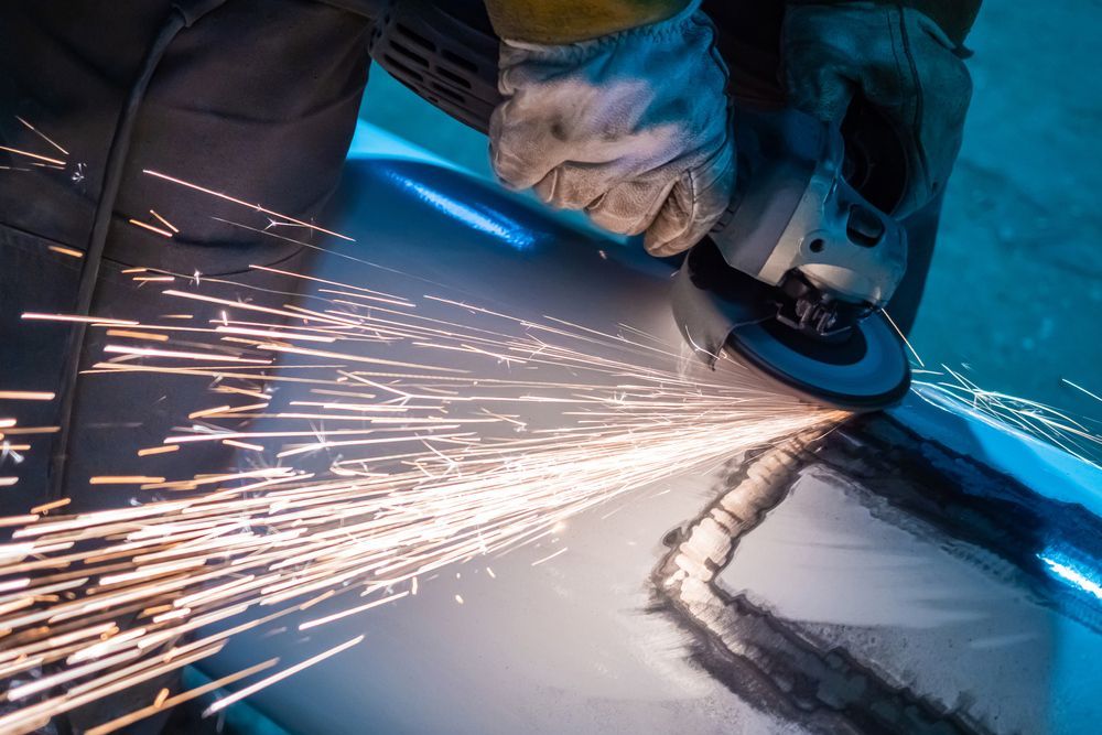 A person is grinding a piece of metal with a grinder.