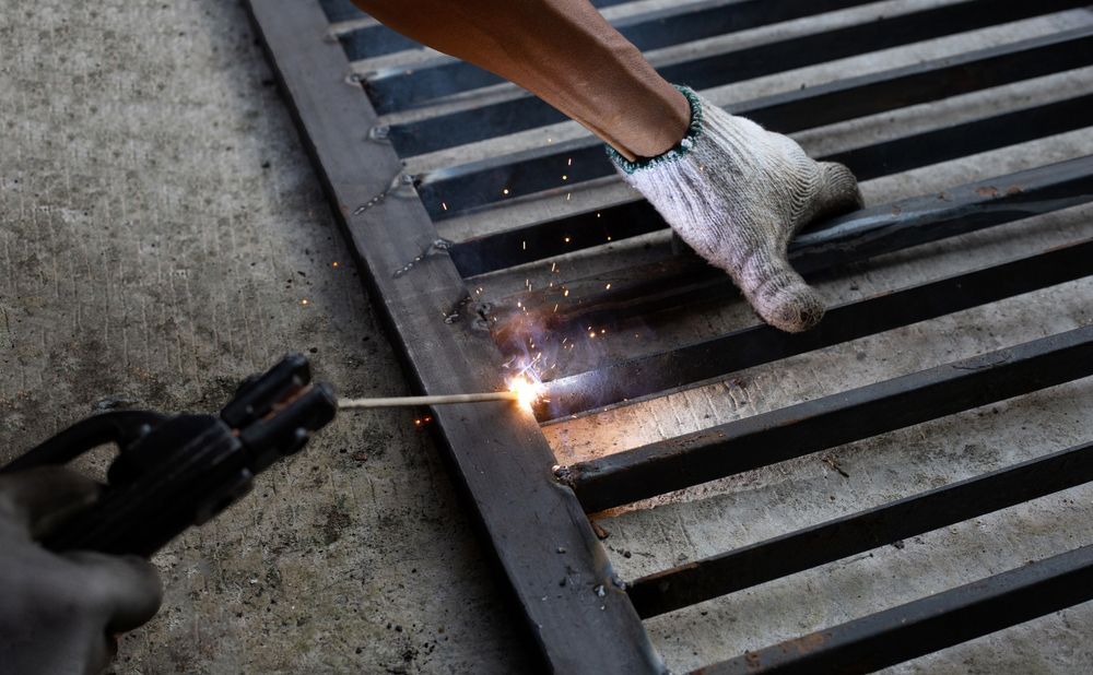 A person is welding a piece of metal with a welding machine.