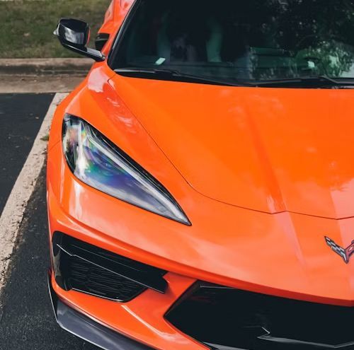 A metal transmission housing and its valve body component placed on a grey workshop surface.