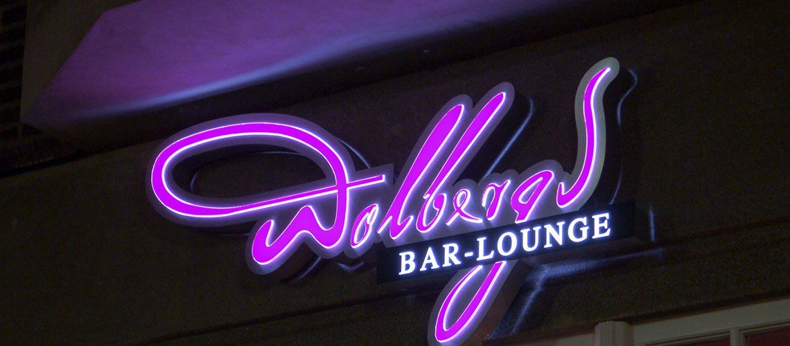 Eine Neonreklame für Wallogg's Bar Lounge leuchtet nachts.