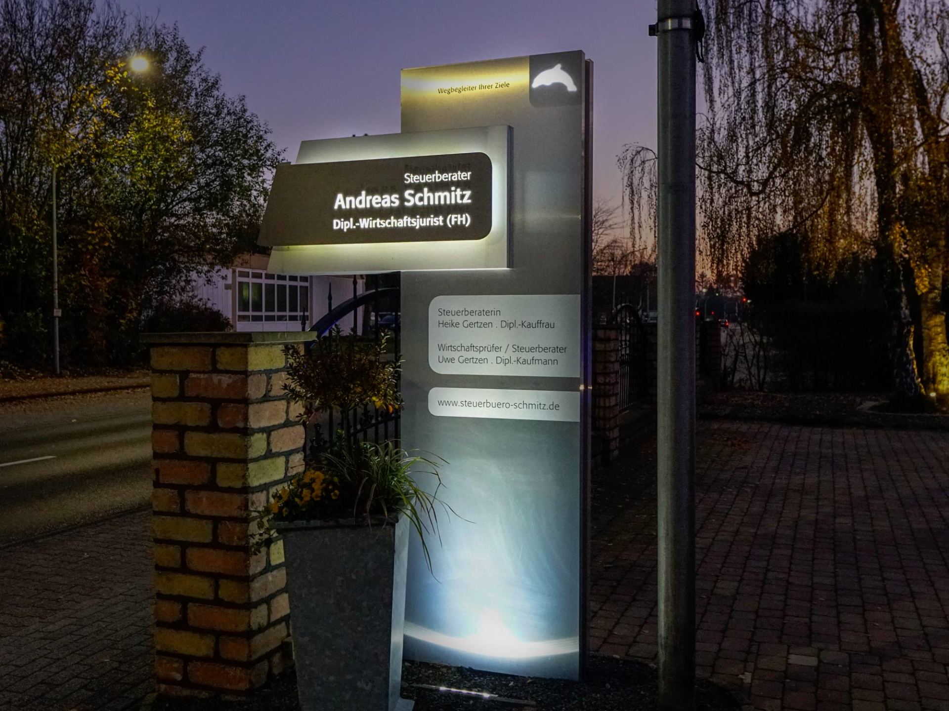 Ein Schild für Andreas Schmidt ist nachts beleuchtet