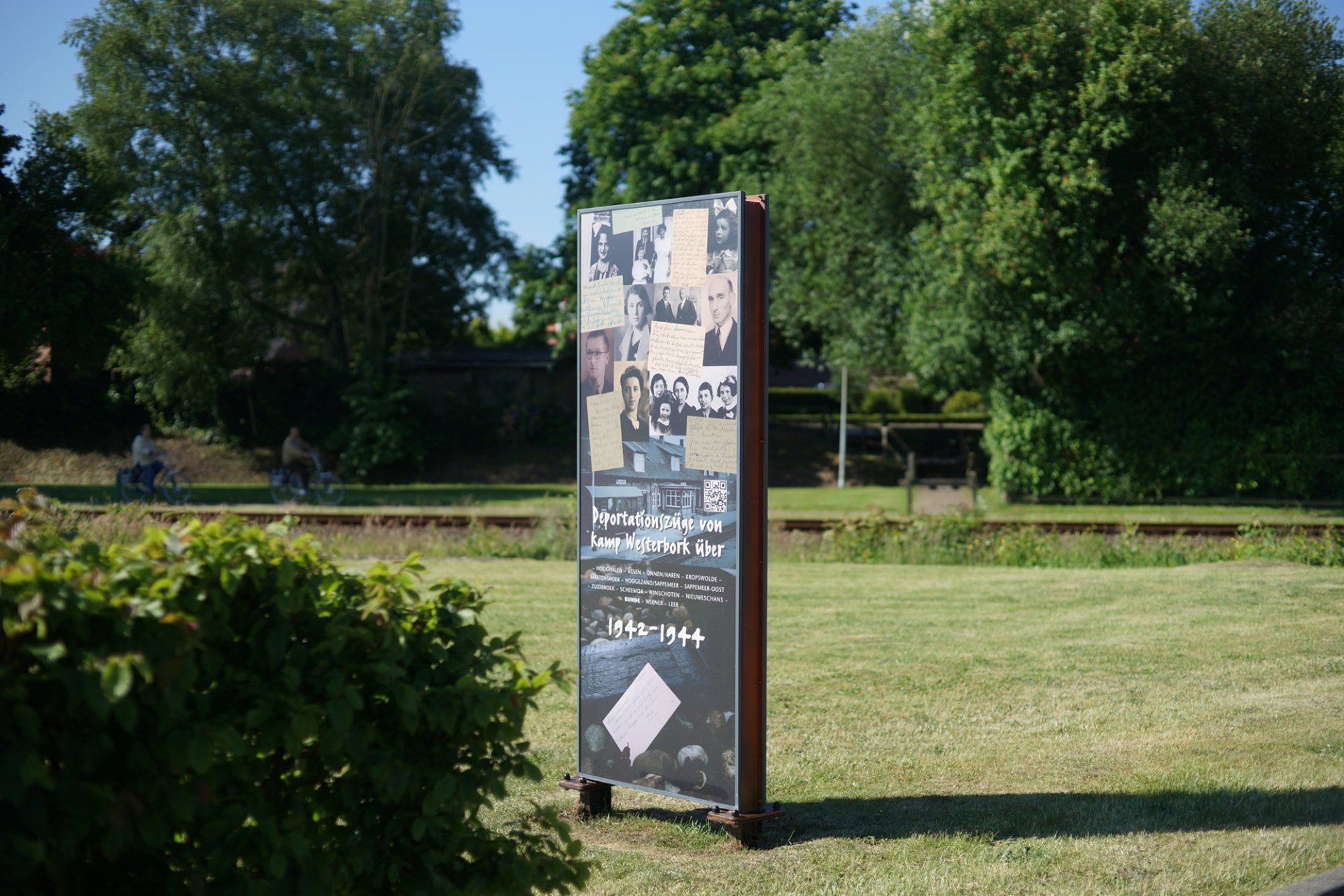 Ein Schild in einem Park mit Bäumen im Hintergrund