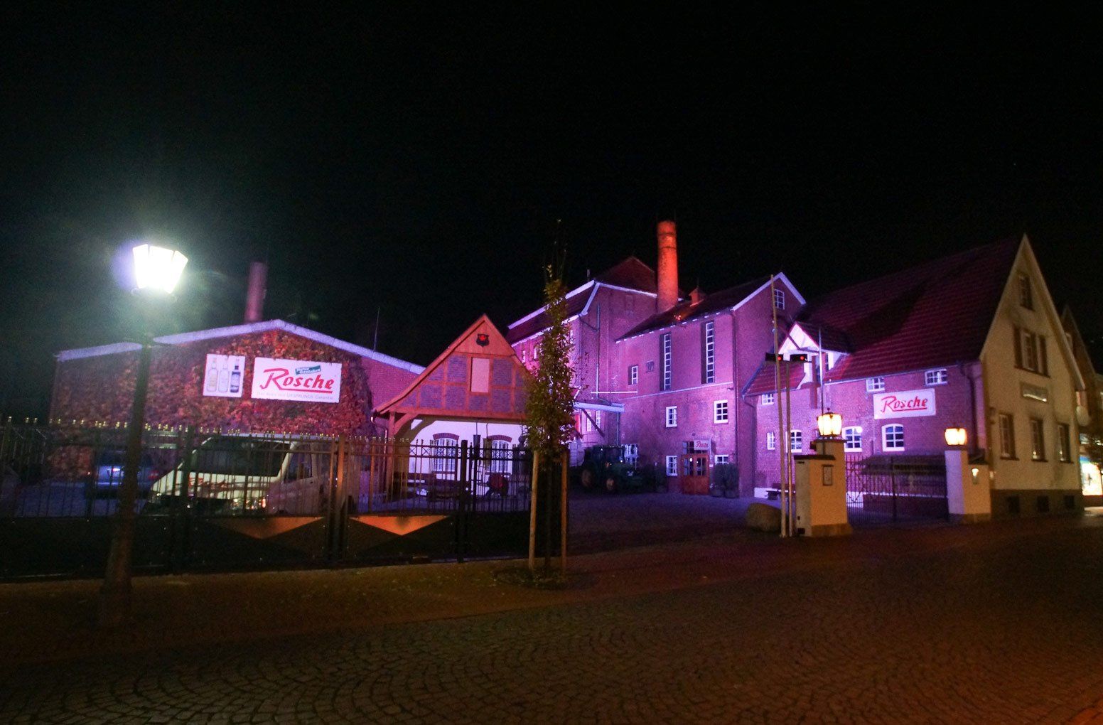 Ein großes Gebäude mit violetten Lichtern wird nachts beleuchtet.