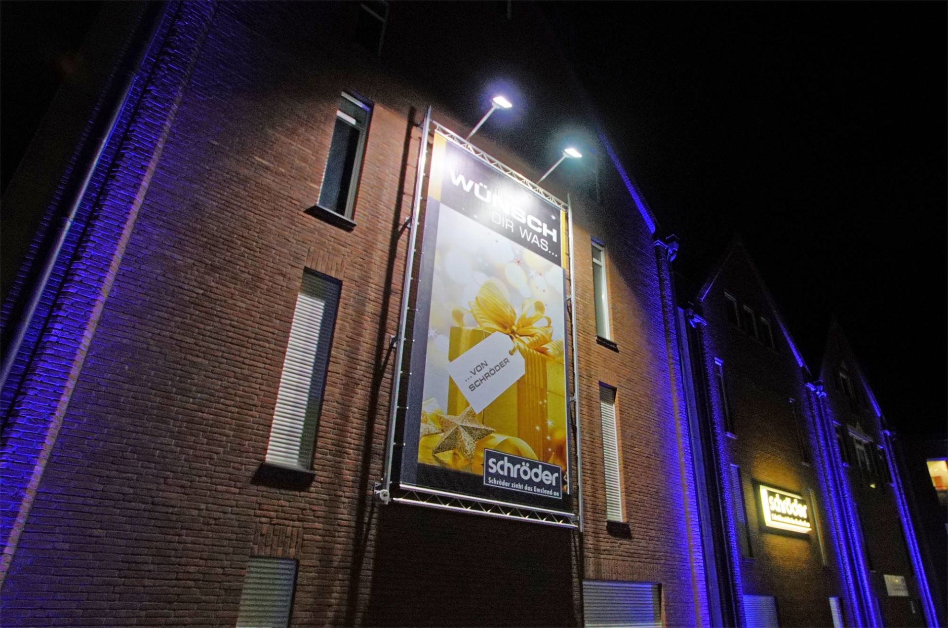 Eine große Plakatwand an der Seite eines Gebäudes in der Nacht