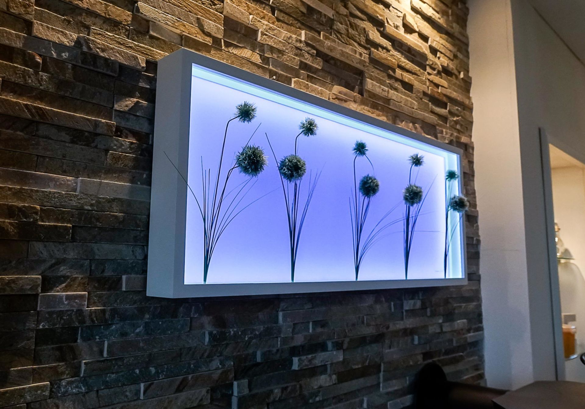 Ein Bild von Blumen hängt an einer Ziegelwand