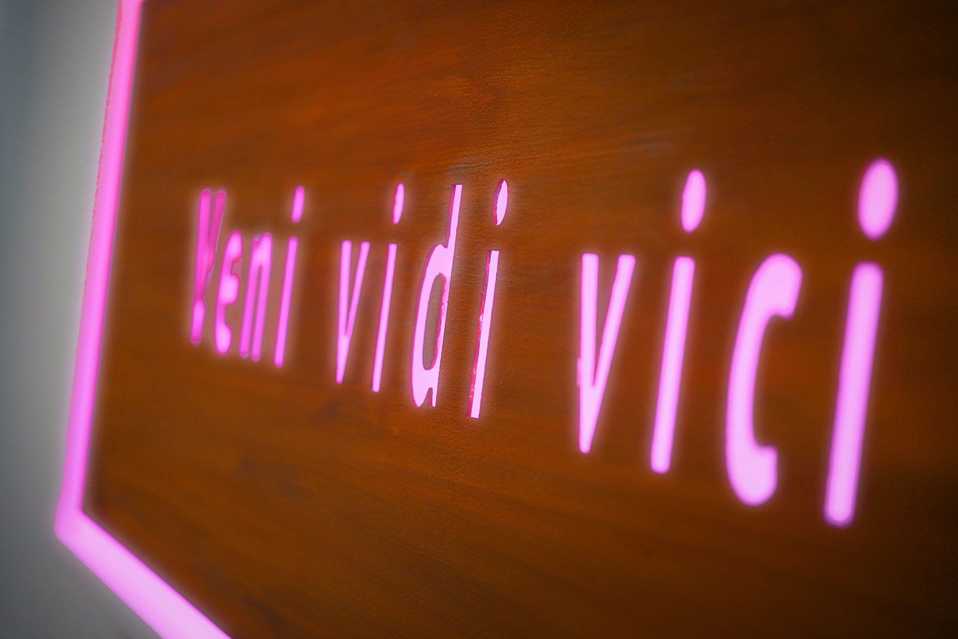 Eine Nahaufnahme eines Neonschildes mit der Aufschrift „Veni vidi vici“.