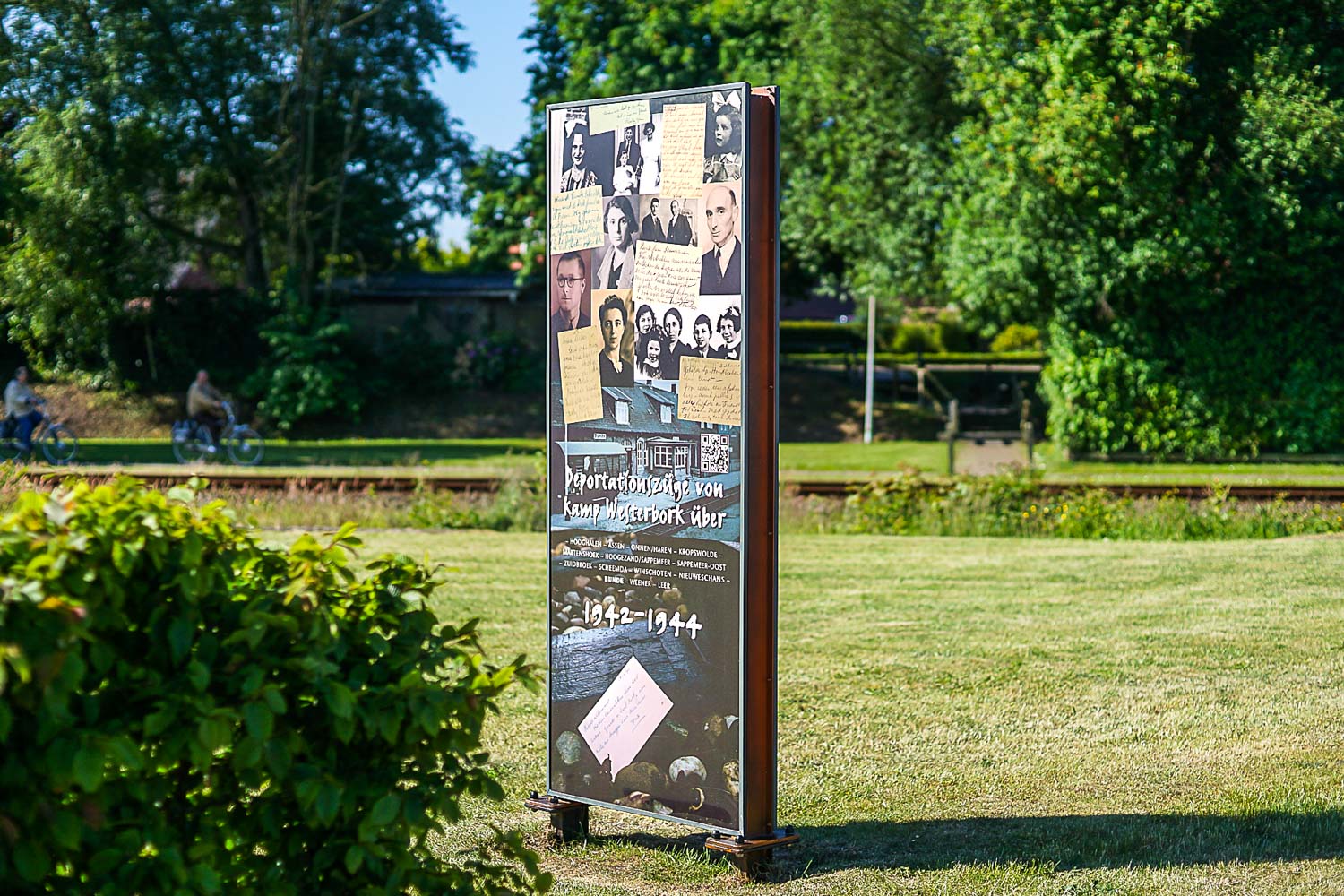 Mitten auf einer Wiese steht ein großes Schild.