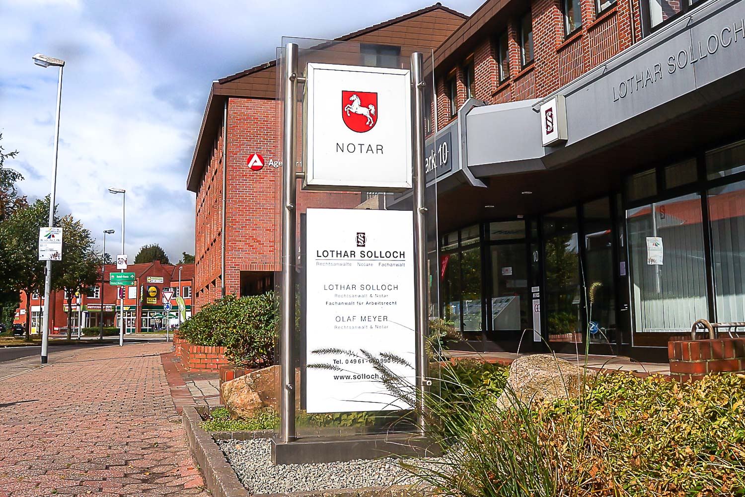 Ein Backsteingebäude mit einem Schild davor, auf dem „Rathaus“ steht.