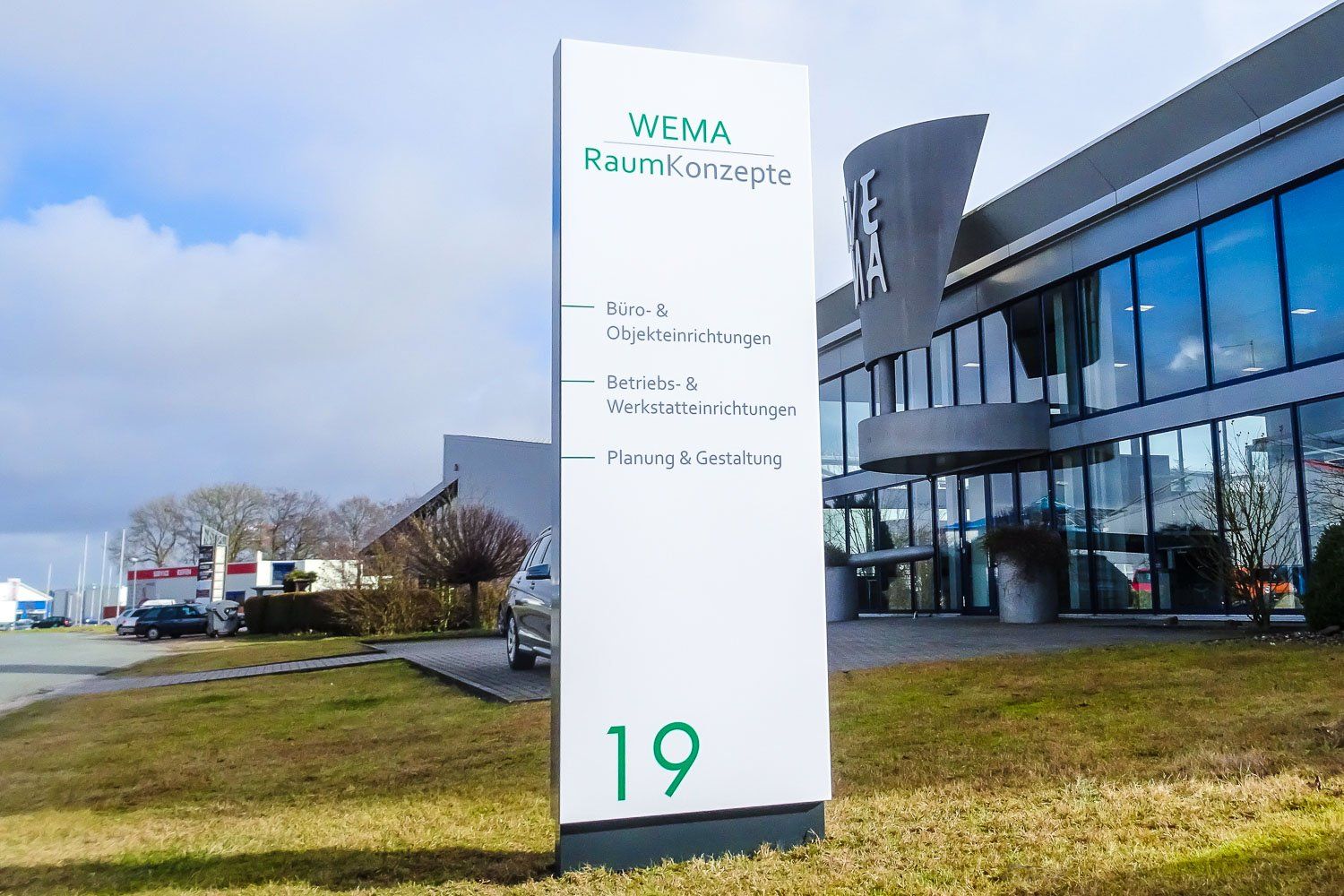 Ein großes Gebäude mit einem Schild davor.