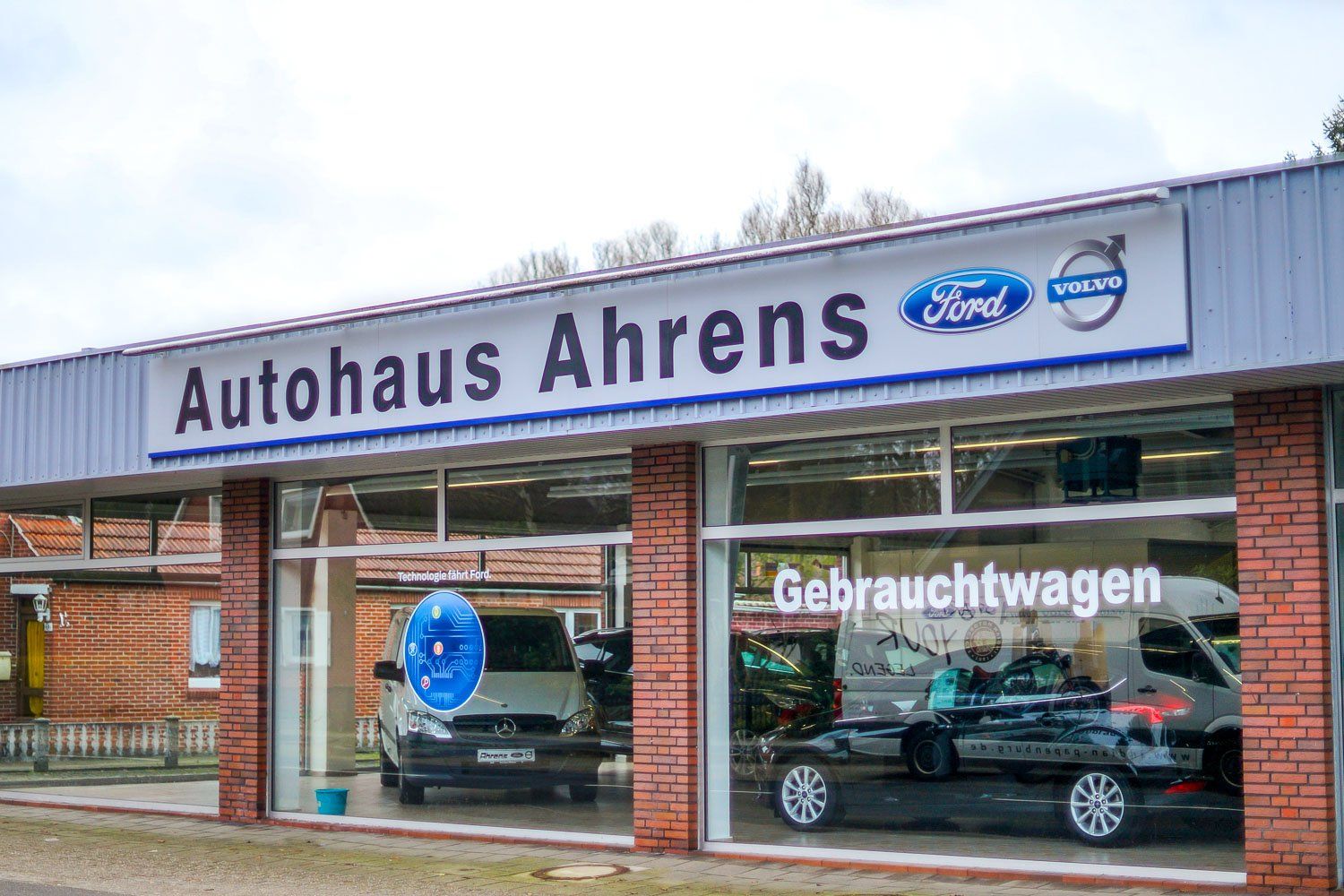 Ein Autohaus mit davor geparkten Autos.